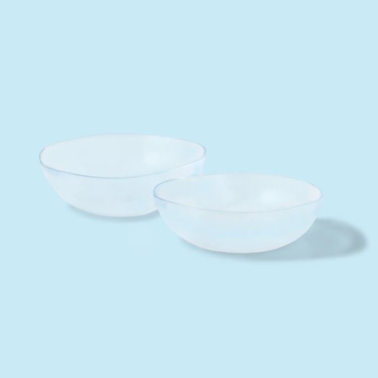 Two contact lenses on a light blue background
